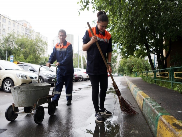 Разнорабочие в Москве помогают убирать улицы после сильного дождя