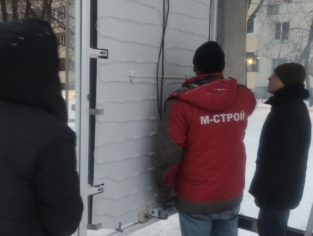 Монтаж автобусных павельенов: разнорабочие производят сборку и крепление рекламного щита